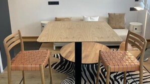 A modern room with a wooden table and chairs, a sofa, and a zebra-patterned rug. - Modern Loft with Panoramic Views (Madrid)