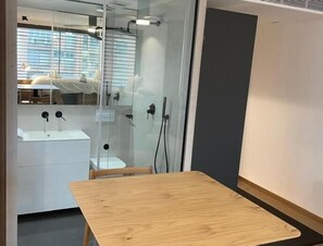 A modern bathroom with a glass partition, a sink, and a shower. - Modern Loft with Panoramic Views (Madrid)