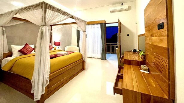 A bedroom with a four-poster bed, a wooden desk, and a nightstand. - Lebak Bali Batu Mejan (Canggu)