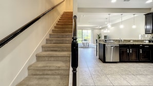 A modern kitchen with dark cabinets, a granite countertop, and stainless steel appliances.