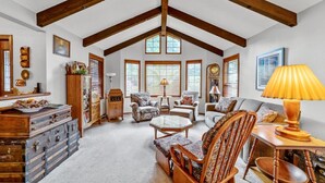 A spacious loft with high ceilings, exposed wooden beams, and large windows.