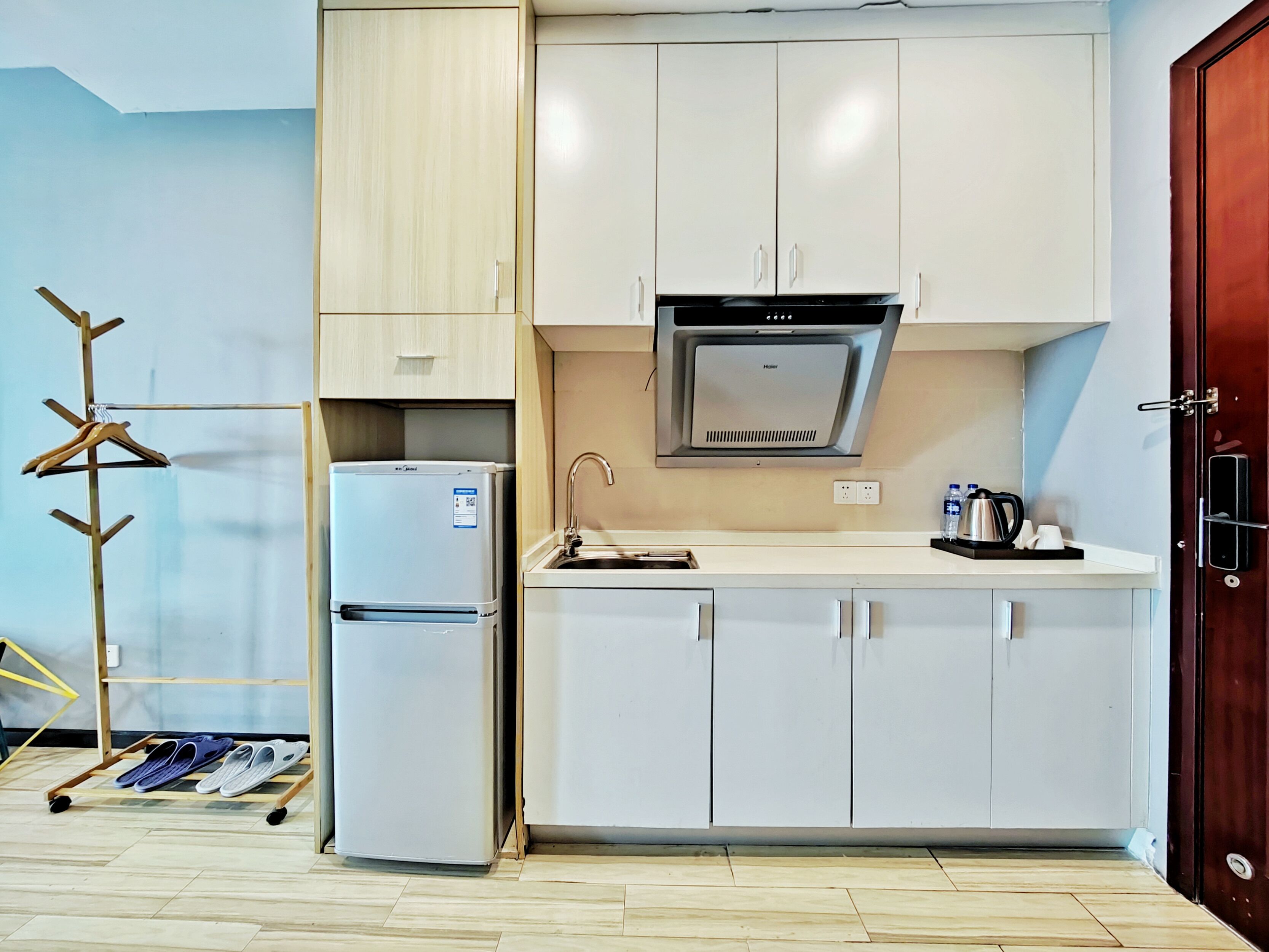 A compact kitchen with white cabinets, a built-in stove, and a refrigerator.