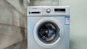 En tvättmaskin med frontmatning, utrustad med en digital display, en kontrollpanel och en klistermärke med en QR-kod.