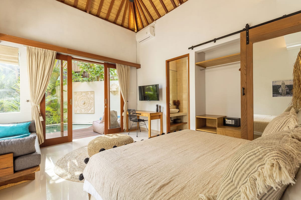 Een ruime slaapkamer met een groot bed, een bureau en een televisie.