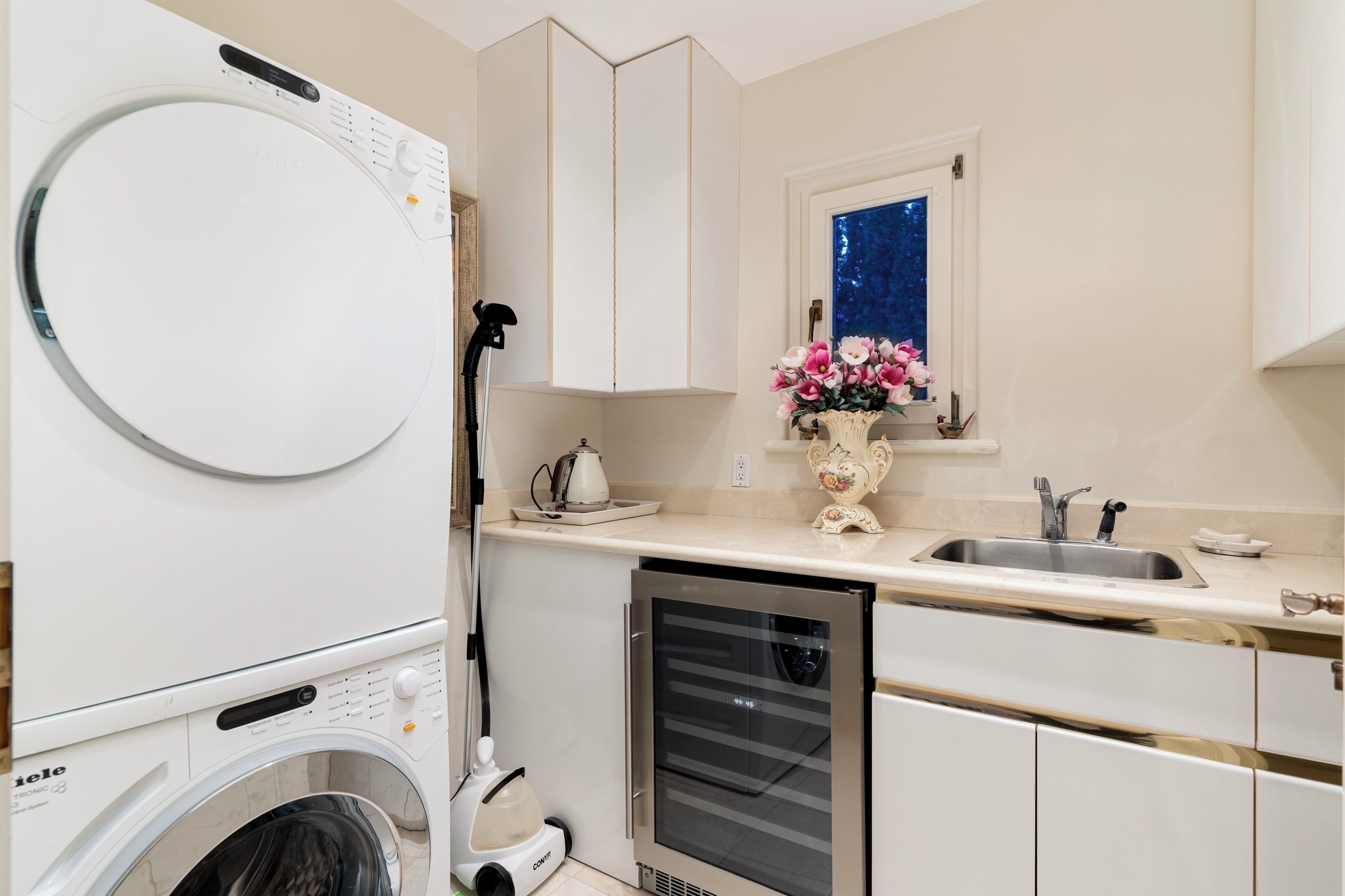 A compact kitchen with a built-in washer and dryer, a dishwasher, and a window with a night sky view.