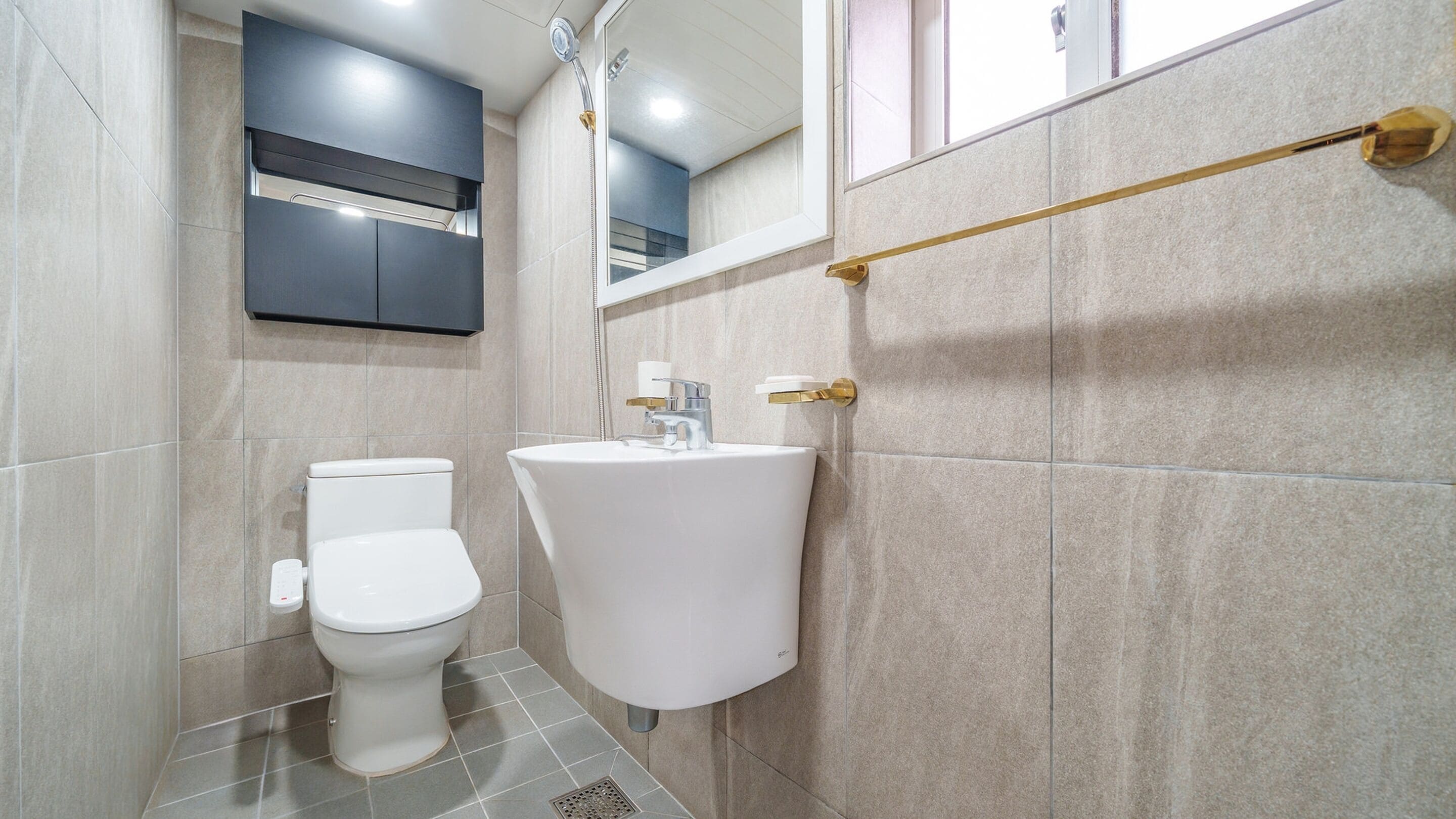 A modern bathroom with a toilet, sink, and mirror.