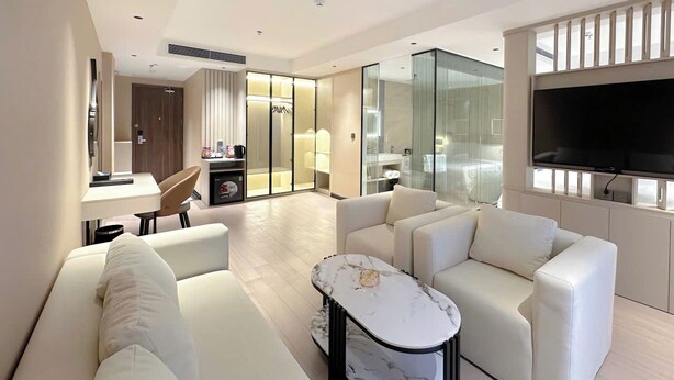 A modern living room with a sofa, a coffee table, and a TV. - GARDEN PHOENIX HOTEL (Vu Ninh)