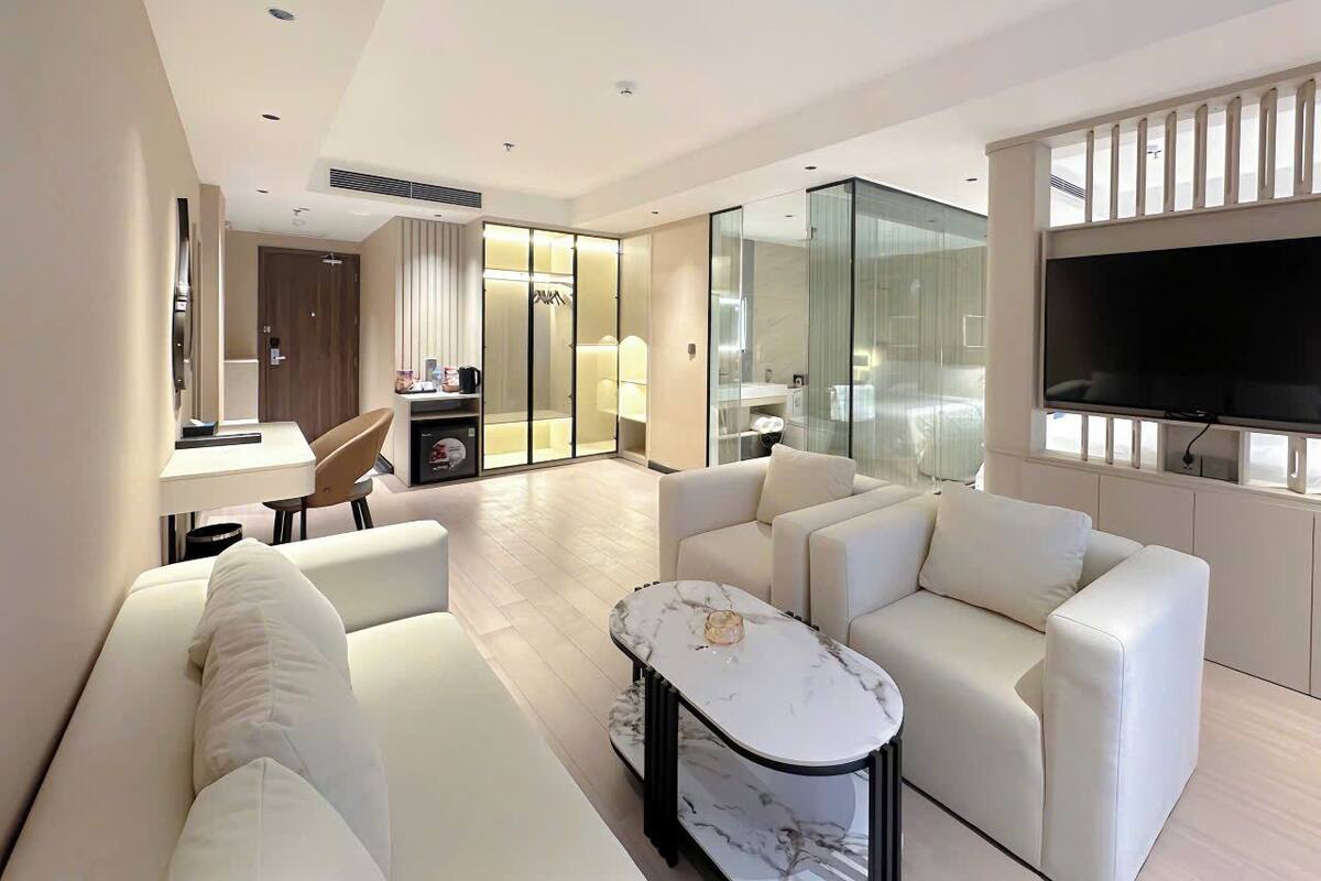 A modern living room with a sofa, a coffee table, and a TV.
