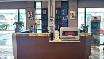 A reception desk with a coffee machine, a scale, and a plant.
