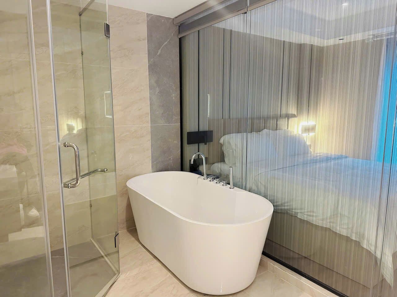 A modern bathroom with a freestanding bathtub, a glass shower enclosure, and a large mirror.