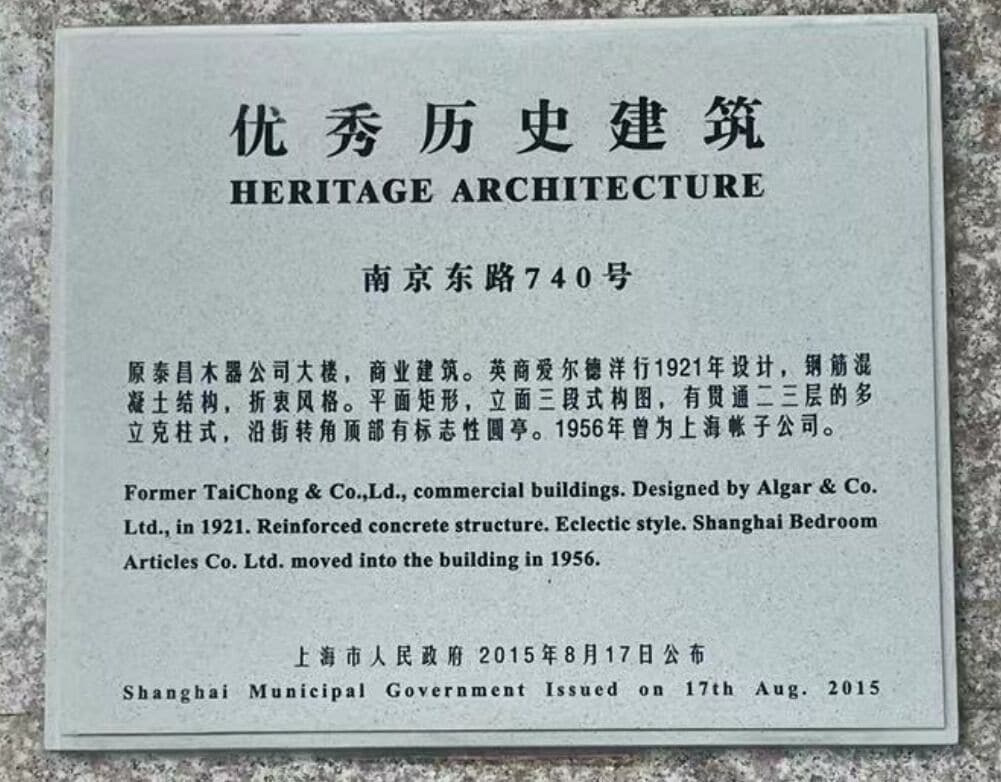 A heritage architecture plaque with text in both Chinese and English, detailing the building's history and architectural style.