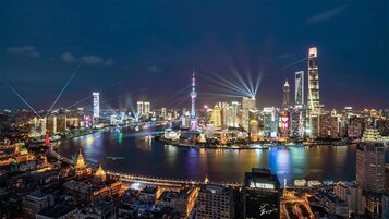 A nighttime cityscape with illuminated buildings and a river.