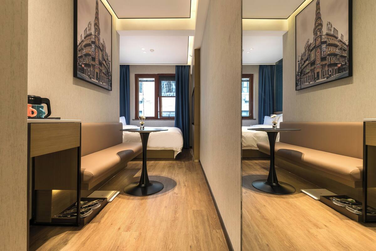 Une chambre d’hôtel avec un lit, un canapé, une petite table et une machine à café.