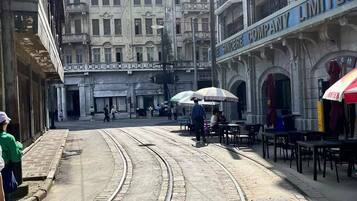 Una calle con tranvía, edificios y terrazas.