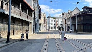 A street with tram tracks, historic buildings, and a clear sky.