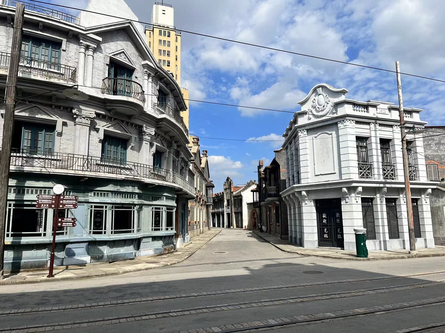 Une rue bordée de bâtiments historiques, dont un bâtiment doté d’une horloge et un autre orné d’un balcon.