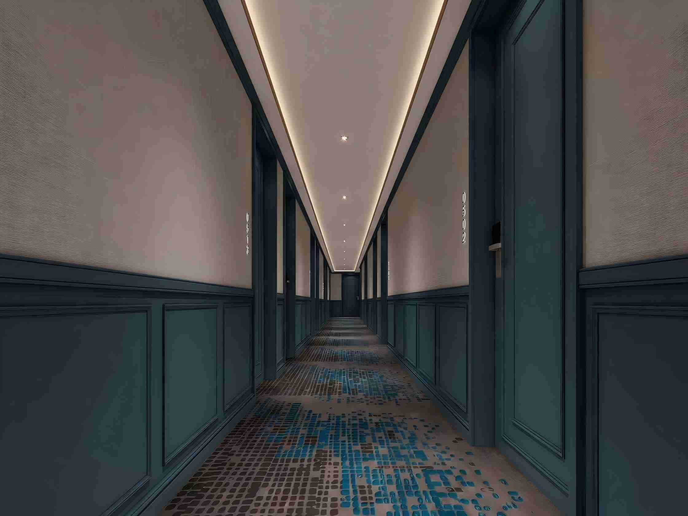 A long, narrow hallway with patterned flooring and large windows on both sides.