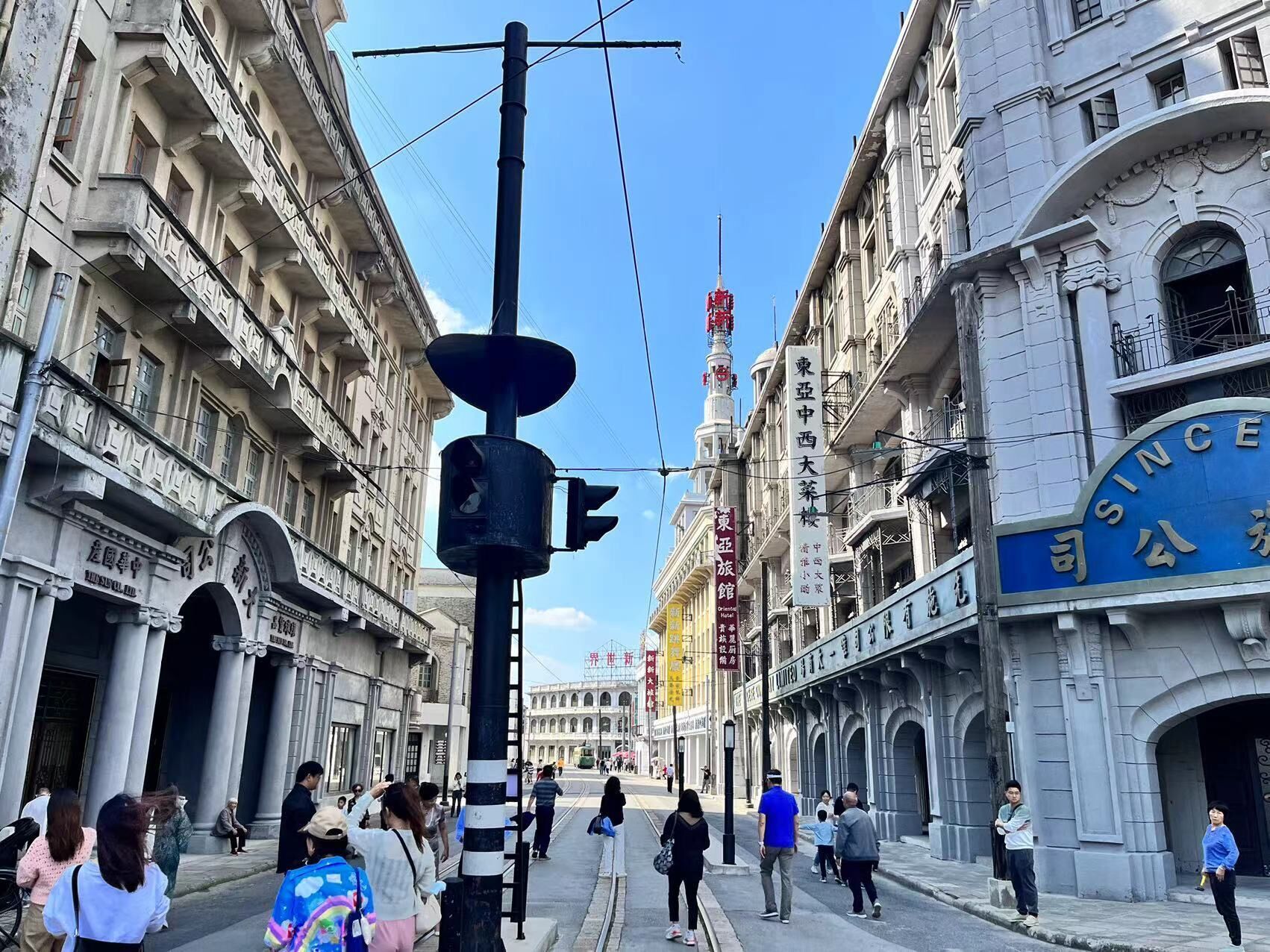 Escena callejera con edificios históricos, un tranvía y peatones.
