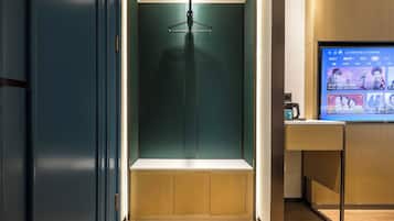 Une chambre moderne avec un bureau en bois, un téléviseur diffusant des images et un luminaire suspendu.