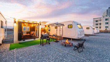 Alojamiento tipo caravana con comedor exterior y zona de barbacoa.