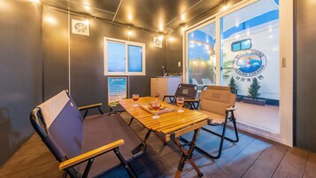 Un interior moderno con una mesa de madera, sillas y vistas a un tren.