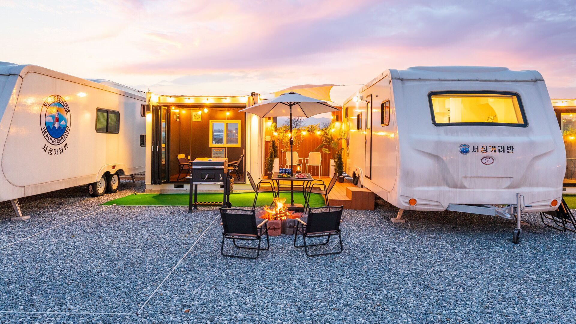 A caravan with a dining area, outdoor seating, and a fire pit.
