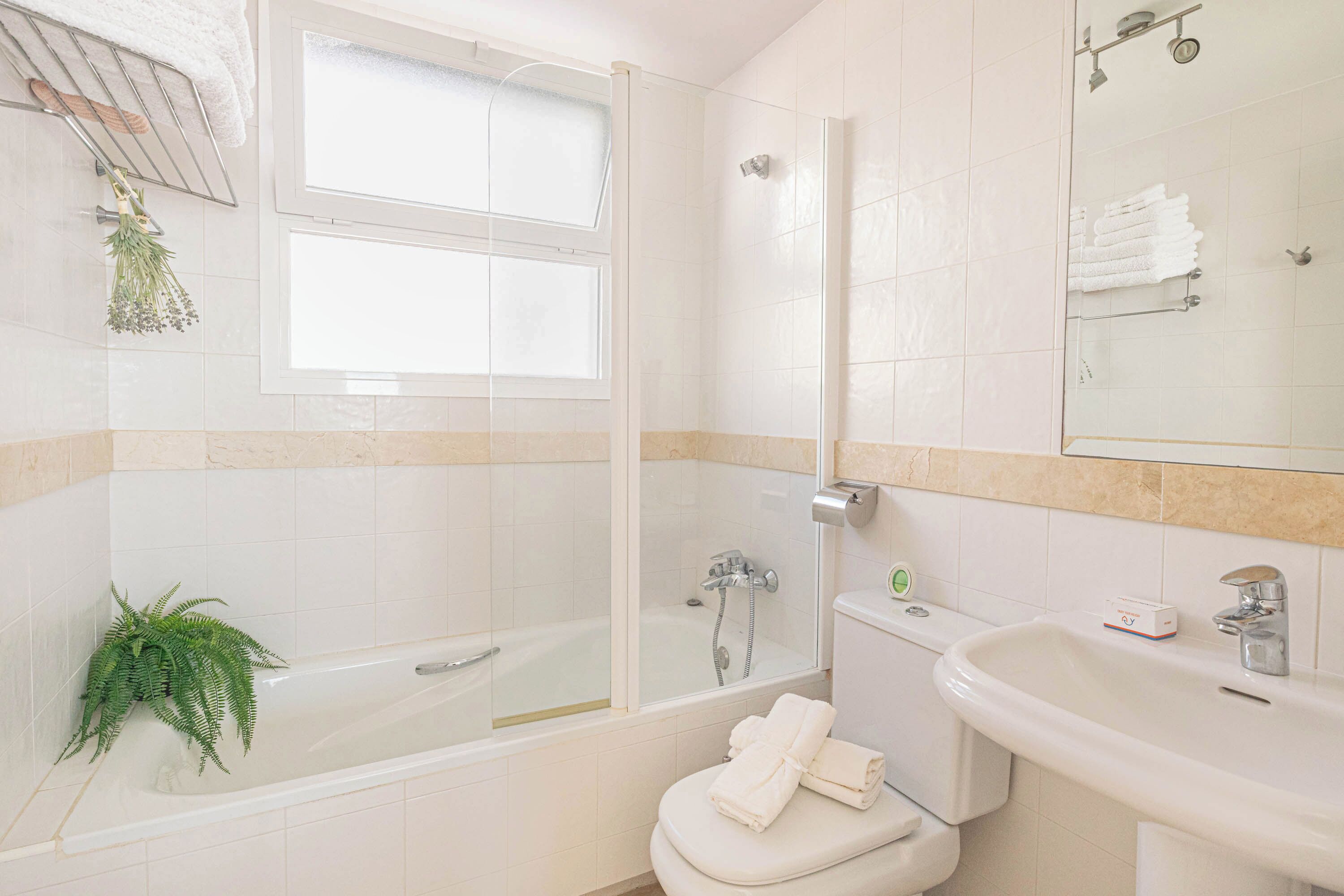Een badkamer met bad, toilet, wastafel en douche.