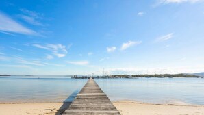 A wooden pier extending into calm waters with a clear sky above. - Bangalee 2 at Sunrise - waterfront apartment (Soldiers Point)