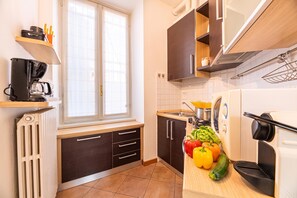 Uma cozinha moderna com uma janela, eletrodomésticos embutidos e uma variedade de produtos frescos na bancada.