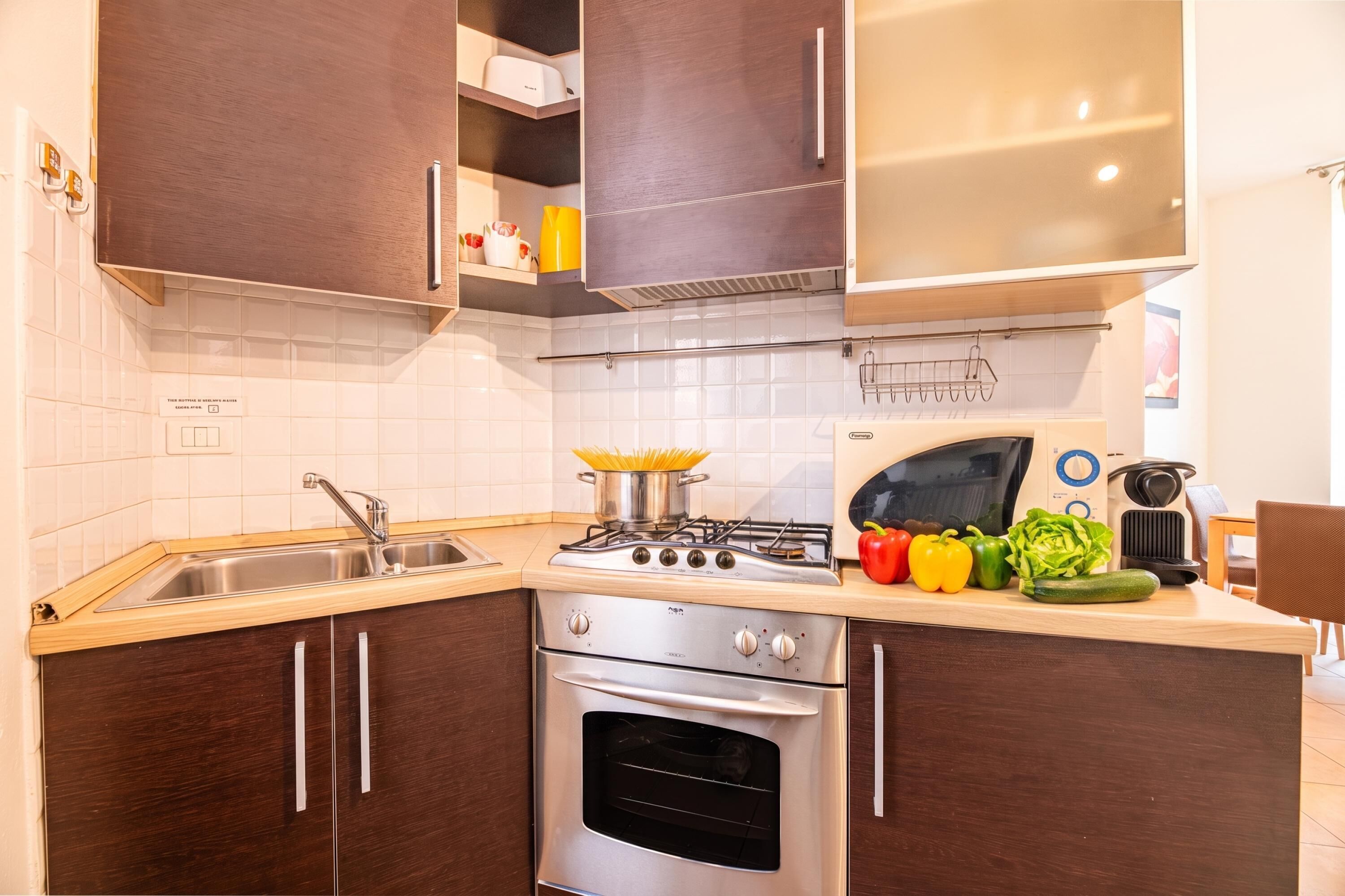 A kitchen with dark wooden cabinets, a stainless steel stove, a sink, and a microwave.