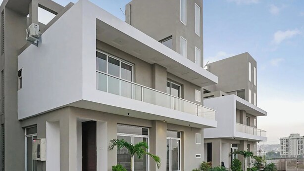 Un edificio residencial moderno de varios pisos con balcones, ventanas amplias y techo plano.