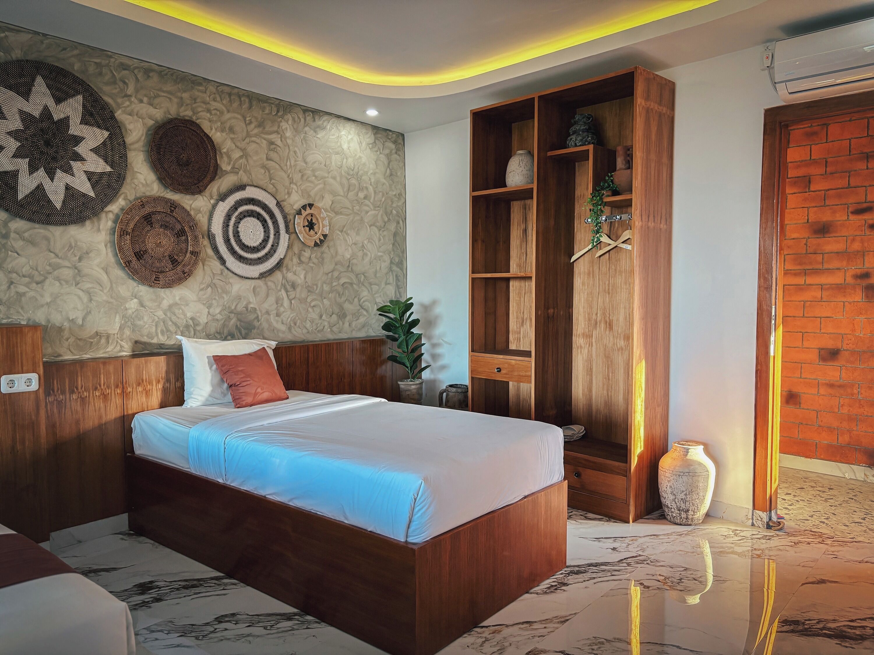 A modern bedroom with a wooden bed, a built-in wardrobe, decorative wall art, and a marble floor.