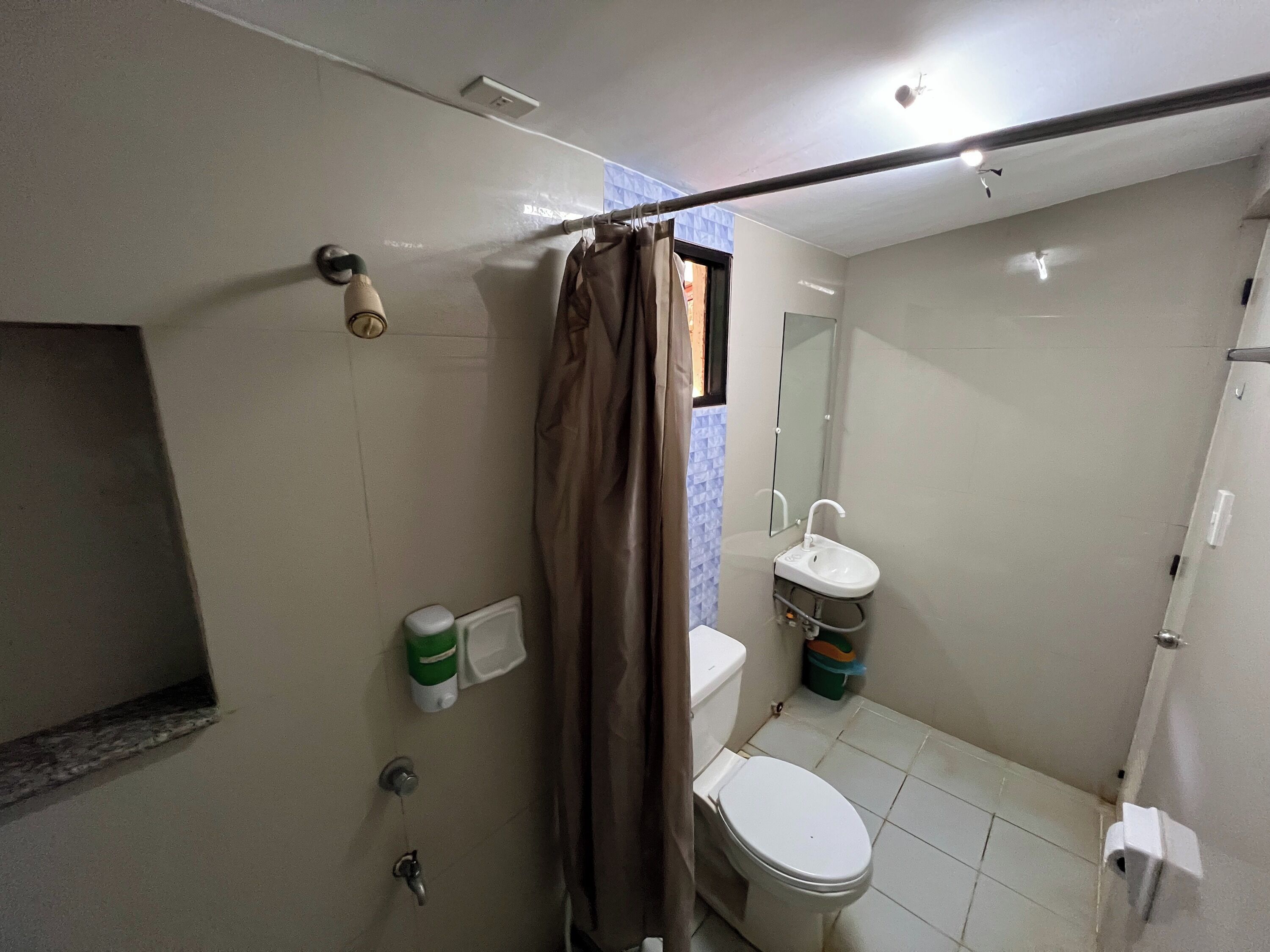A bathroom with a toilet, sink, and shower area.