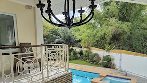 A pool area with a hot tub, a covered seating area with a railing, and a view of the surrounding greenery. - Elicon Suites Resort Bohol near City Center (Baclayon)