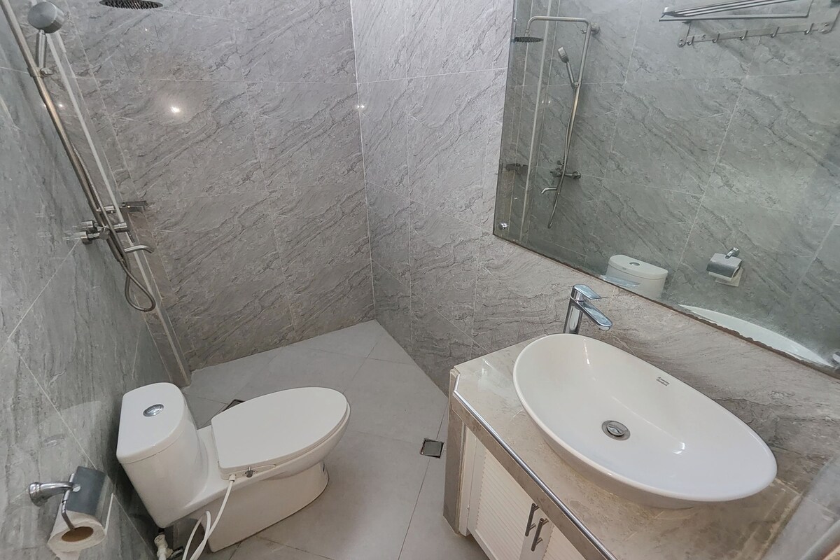 A modern bathroom with a toilet, sink, and shower.