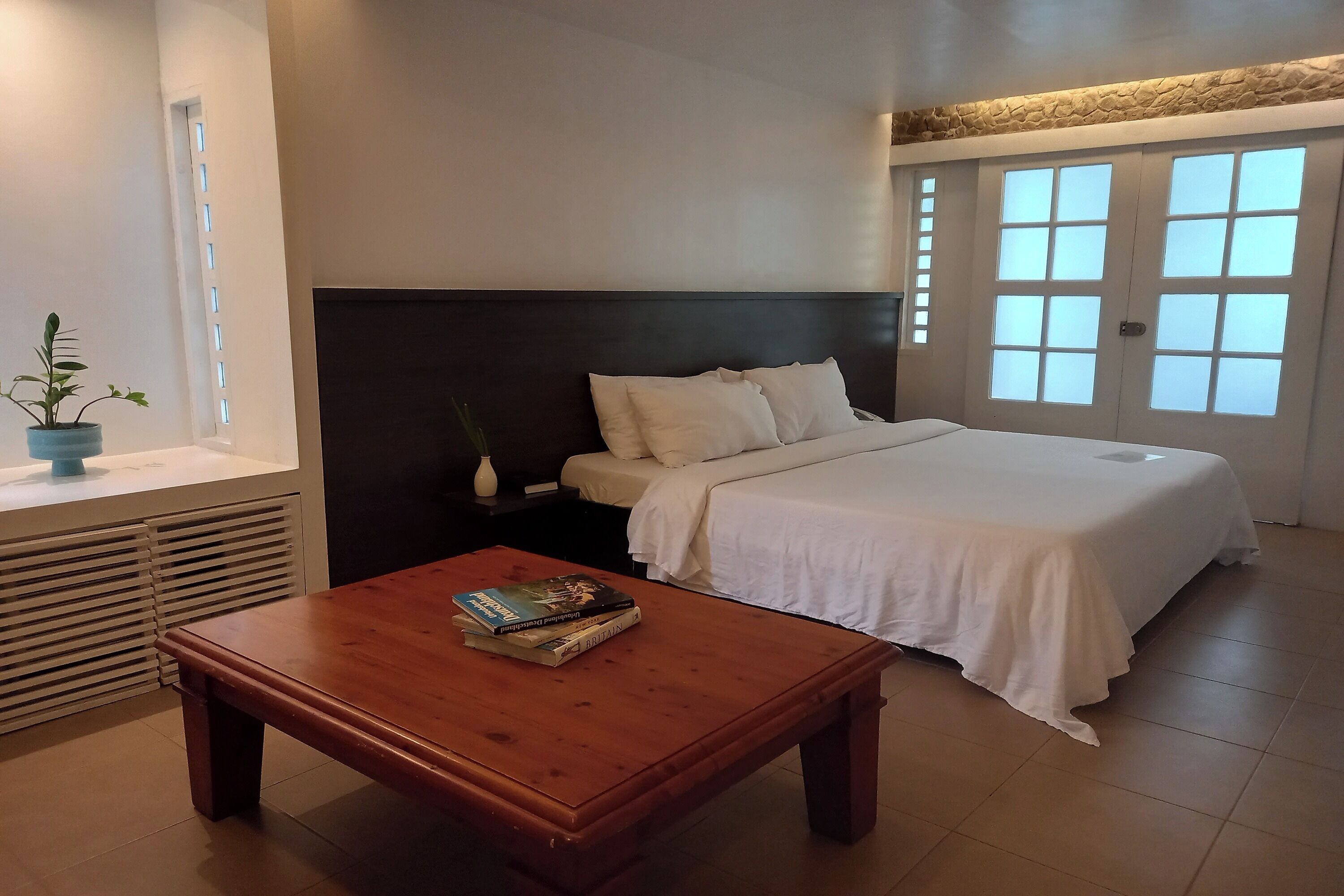 Un dormitorio con cama, mesita de noche y ventana con vistas.