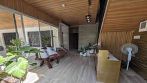 A modern interior with a wooden ceiling, a reception desk, potted plants, and a bench. - Manuela Suites Puerto Princesa near Airport (Puerto Princesa)