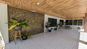 A spacious indoor area with a patterned wall, several potted plants, and a tiled floor. - Manuela Suites Puerto Princesa near Airport (Puerto Princesa)