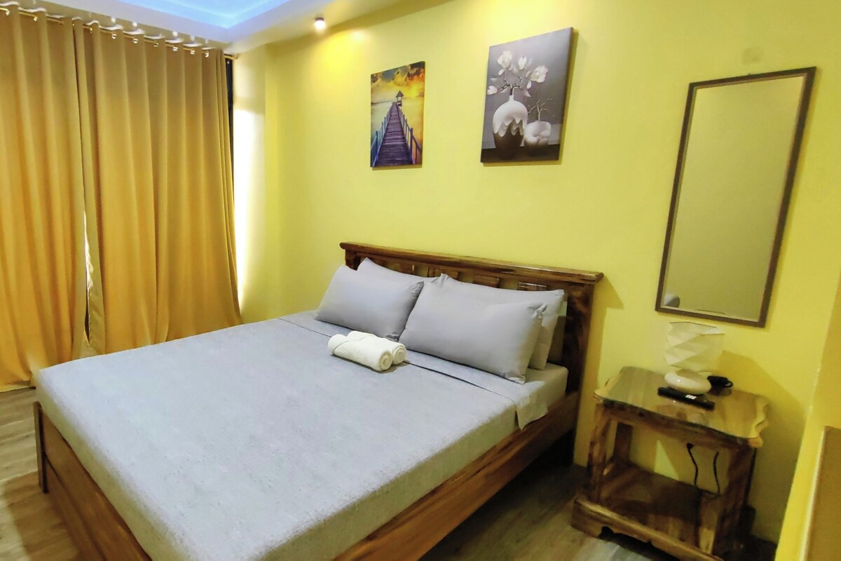 Une chambre à coucher avec un lit, une table de chevet et un miroir.