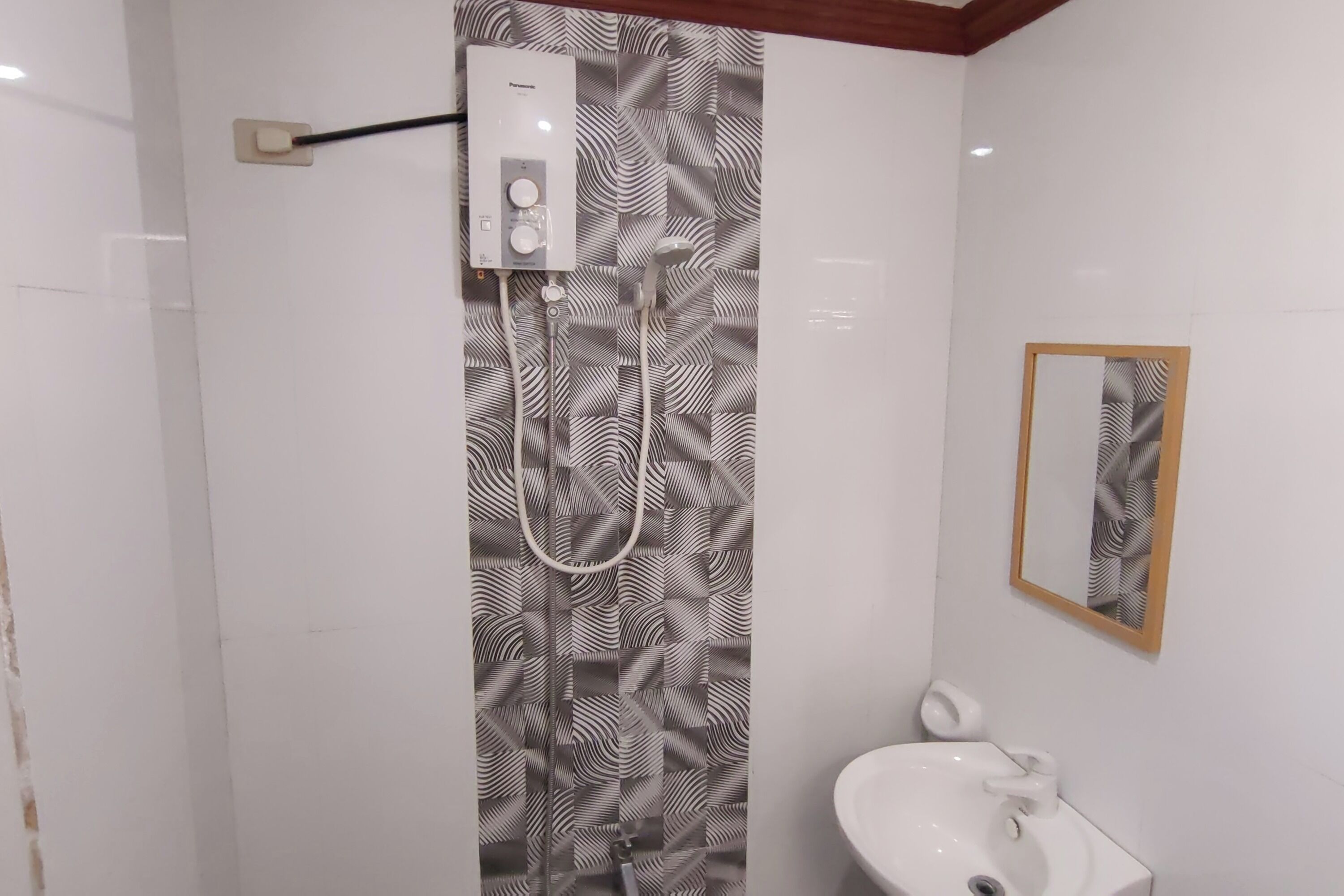 Un baño con ducha, lavamanos y espejo.