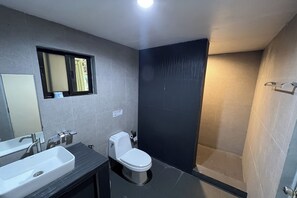 Een moderne badkamer met een wastafel, toilet en douchehoek.