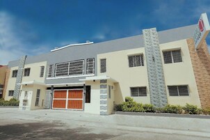 A modern two-story building with a garage, large windows, and a sign indicating a business or commercial use.