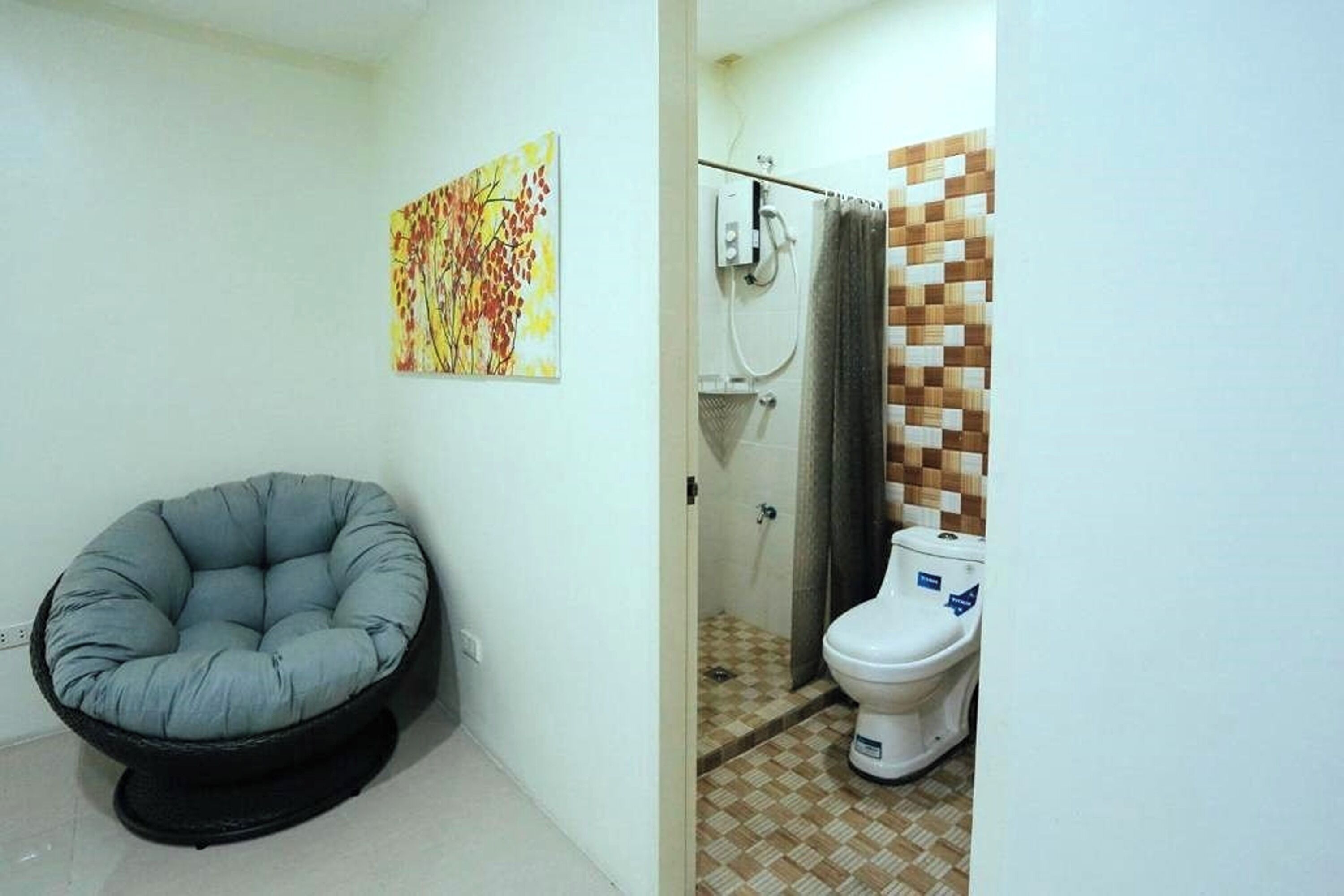 Un baño con ducha, inodoro y una silla.