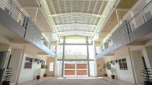 A spacious atrium with a high ceiling and a central open door leading to another area. - Ljenj Apartelle (Mabalacat City)