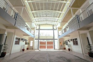 A spacious atrium with a high ceiling and a central open door leading to another area.