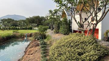 Surrounded by a serene water feature and lush greenery, this tranquil retreat offers a peaceful escape.