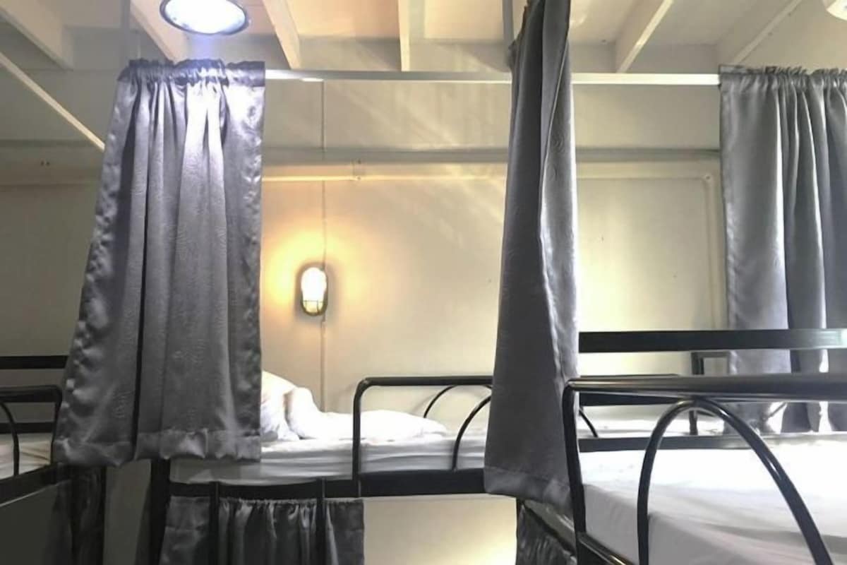 A bunk bed room with a single bed and a nightstand.