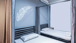 A compact hotel room with two single beds, a large mirror, and a ceiling-mounted air conditioner. - Ali Hostel (Bangkok)