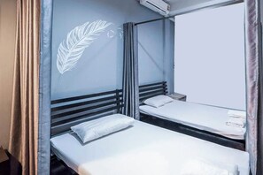A compact hotel room with two single beds, a large mirror, and a ceiling-mounted air conditioner. - Ali Hostel (Bangkok)
