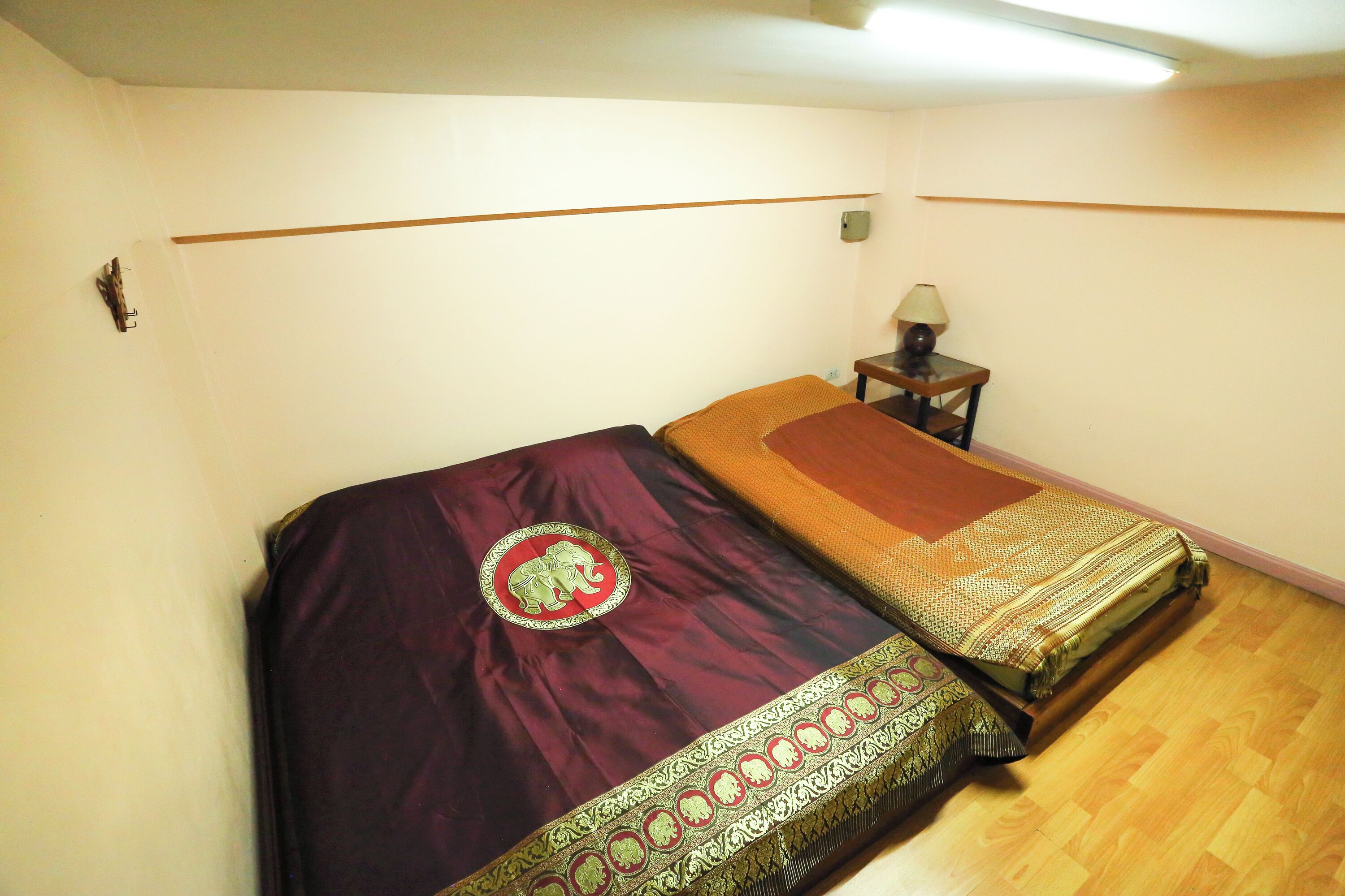 A bedroom with a single bed, a nightstand, and a lamp.